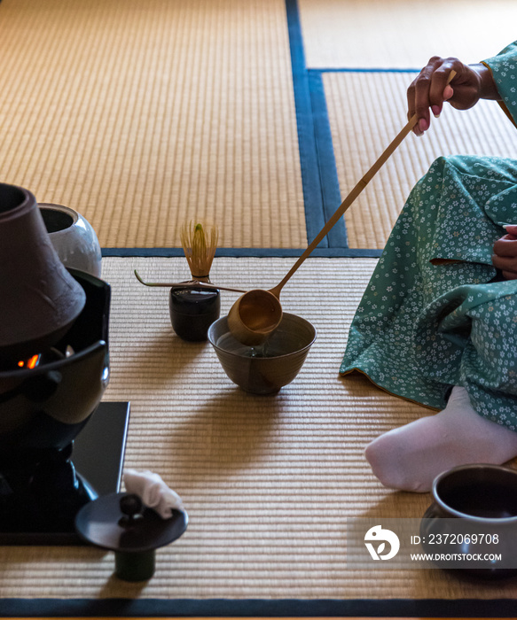 黑人女性客人用Hishaku竹勺将热水倒入装满w的茶碗