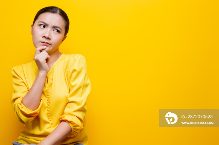 Woman feel confused isolated over yellow background