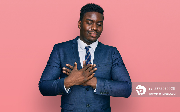 Handsome business black man wearing business suit and tie smiling with hands on chest with closed ey