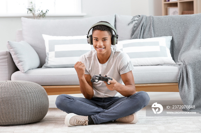 快乐的非裔美国少年在家玩电子游戏