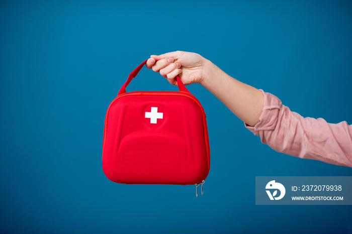 Holding first aid kit on the blue background