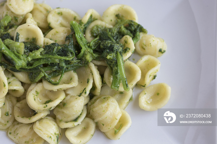 Orecchiette con le cime di rapa fatte in casa in un piatto rettangolare. Cibo pugliese.