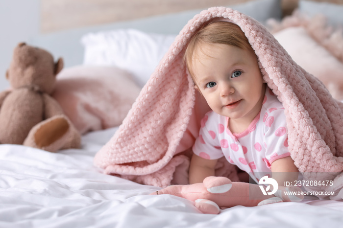 Portrait of cute little baby on bed at home