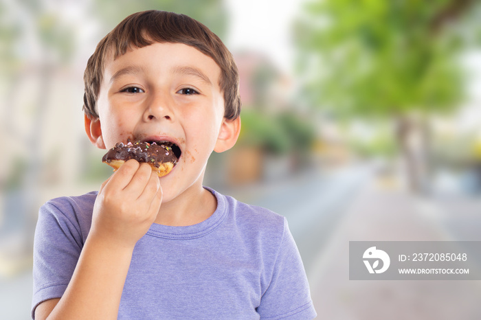 Portrait of a young boy child eating donut town copyspace copy space unhealthy sweet sweets