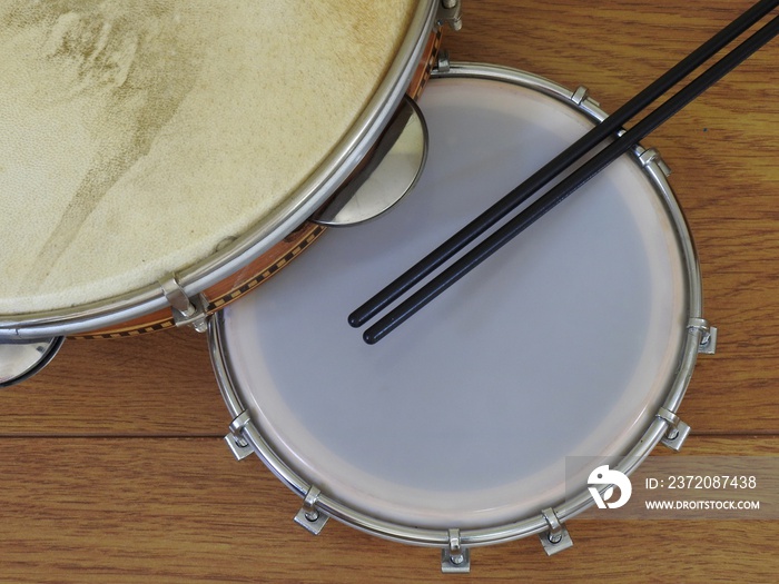 Two Brazilian percussion musical instruments: pandeiro (tambourine) and tamborim with drumstick, on 