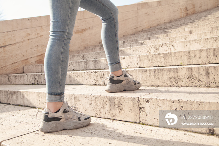 Young woman walking up the stairs in city.