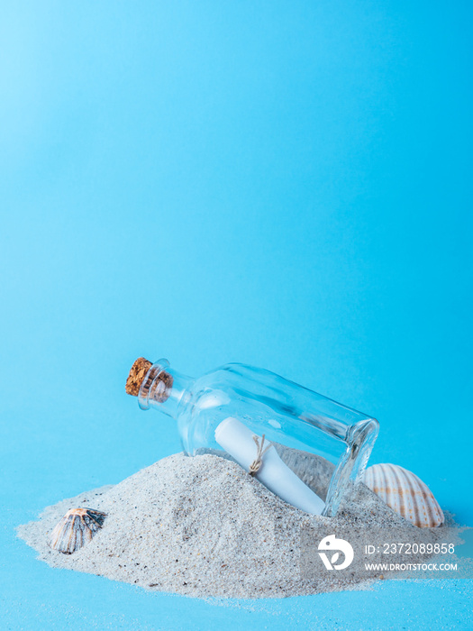 bottle with a message on sand with blue background