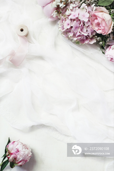 女性花卉框架构图。美丽的粉色牡丹、绣球花和玫瑰在白色musl上绽放