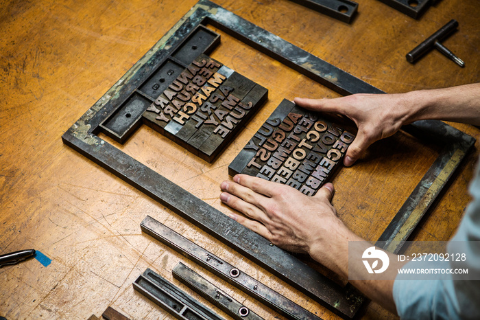 Mans hand working with letterpress in workshop