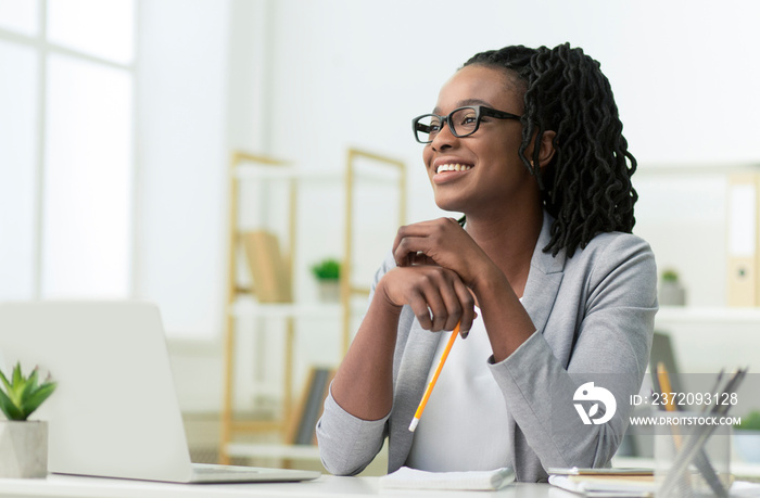 Smiling Black Business Lady Sitting At Laptop At Workplace