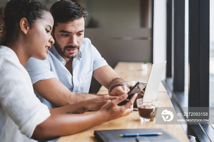 Young man and woman working on laptop and using mobile phone relax in business office