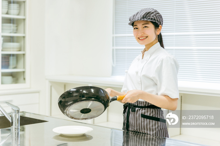 フライパンで料理する女性