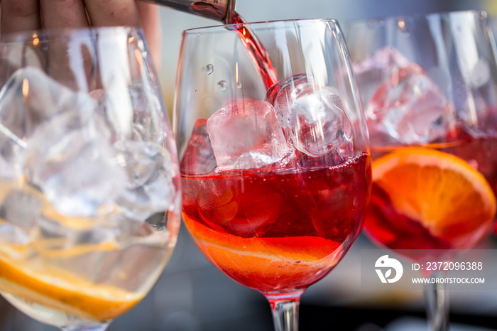 glasses of cocktails on the bar. bartender pours a glass of sparkling wine with Aperol.