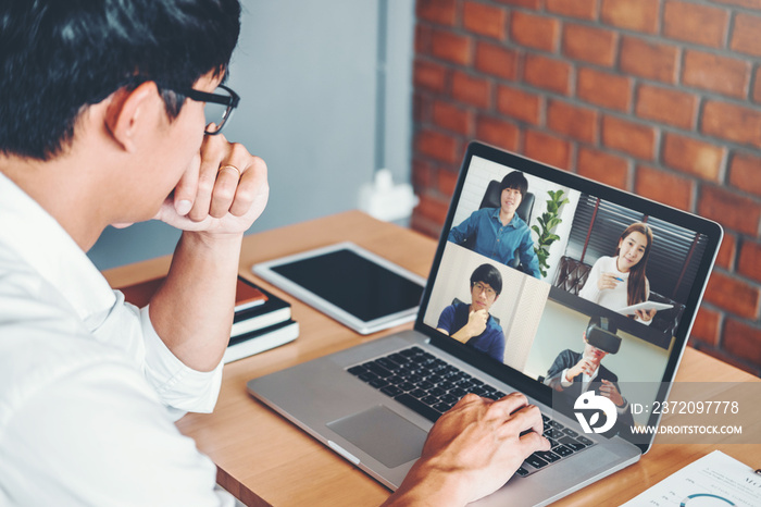 亚洲男子在家工作使用智能工作和视频会议与亚洲团队的在线会议