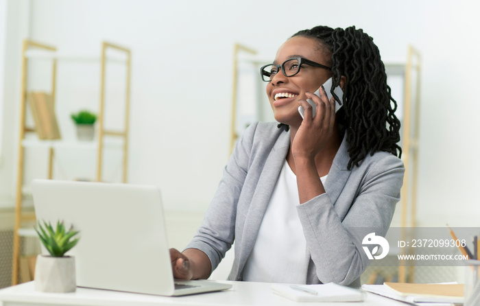 Black Entrepreneur Lady Talking On Cellphone Sitting In Modern Office