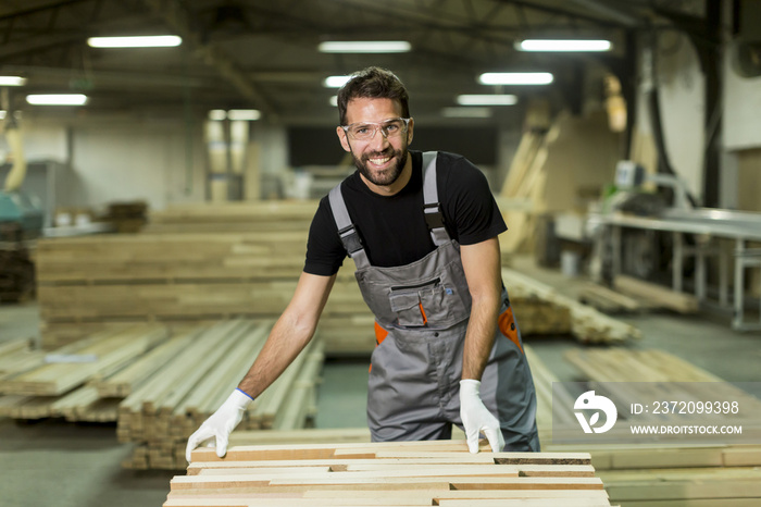 Young worker works in a factory for the production of furniture