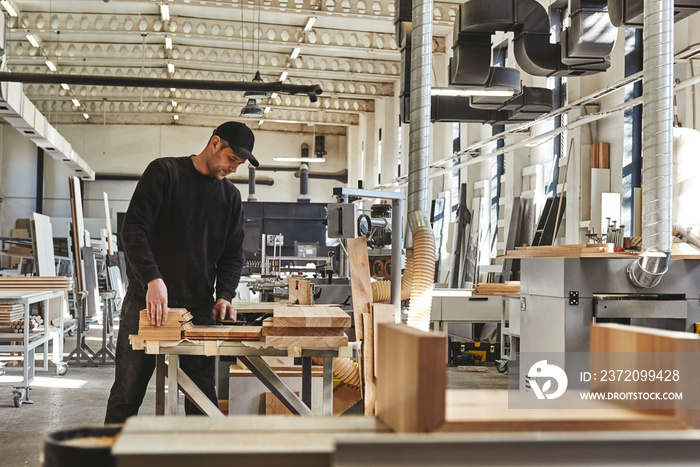 100 Quality. Craftsman in black uniform work at his workstation