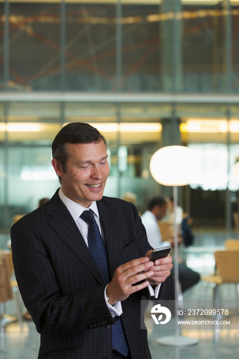 Corporate businessman using smart phone in office