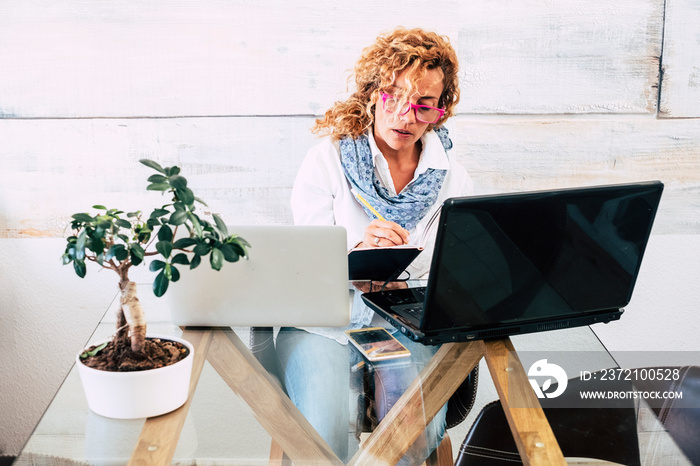 Business woman at office with double laptop workstation - concept of stress and work for people - ho