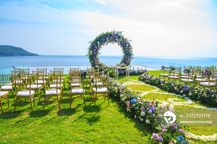 婚礼。拱门，草坪上装饰着鲜花，海滩背景，夏天的大海。