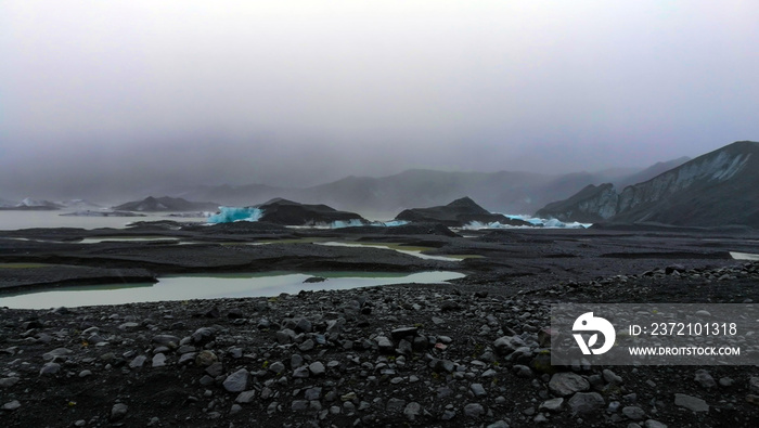 冰岛多云天气冰川徒步旅行——冰雪覆盖的火山黑石景观