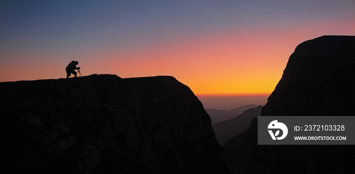 SILHOUETTE：摄影师准备他的设备来捕捉阿尔卑斯山的日落。