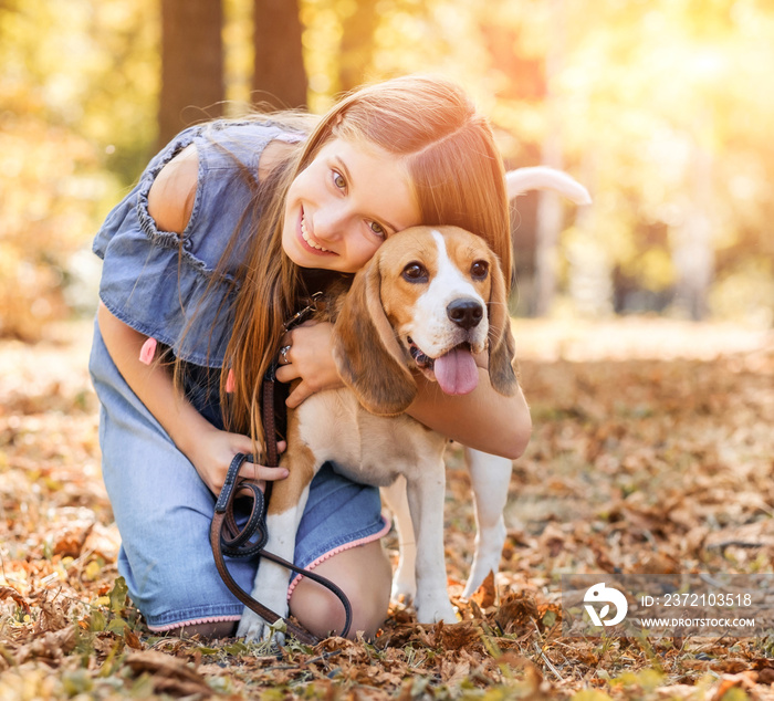 快乐的女孩在外面拥抱比格犬