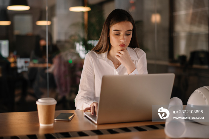 Young businesswoman in office. Beautiful female architect working late night.