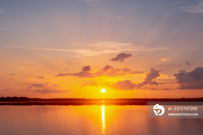 Sunset reflection lagoon. beautiful sunset behind the clouds and blue sky above the over lagoon land