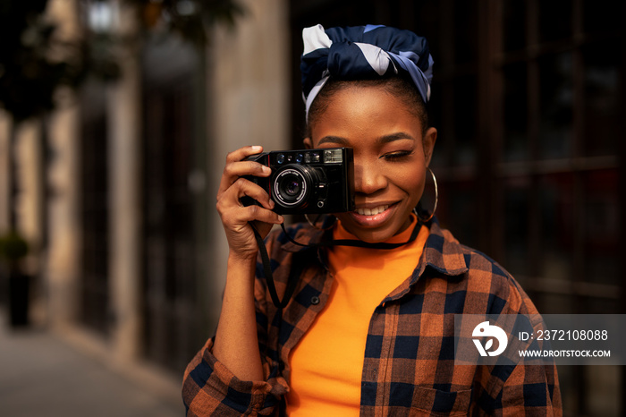 Attractive tourist with a camera. Beautiful woman with camera taking photos of beautiful location.