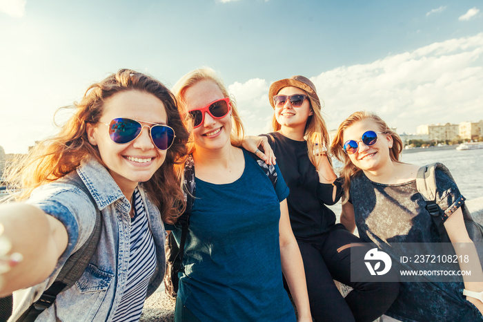 Group of happy smiling carefree young stylish girl female friends on city background, millennials co