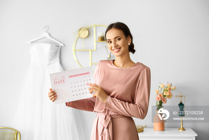 Female wedding planner with Save the Date Announcement in office