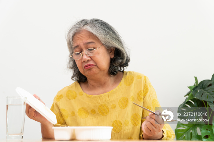 Unhappy Asian senior woman anorexia and say no to ready meals, Elderly home alone and bored food and