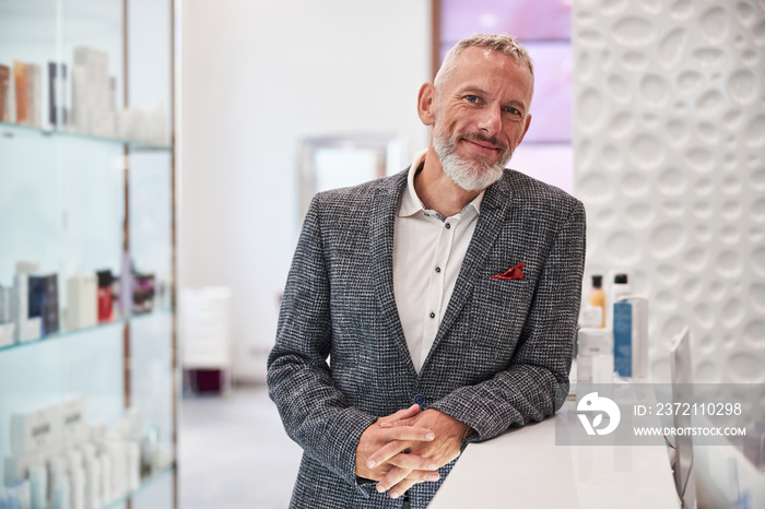 Approachable elderly man in a blazer at a cosmetics store