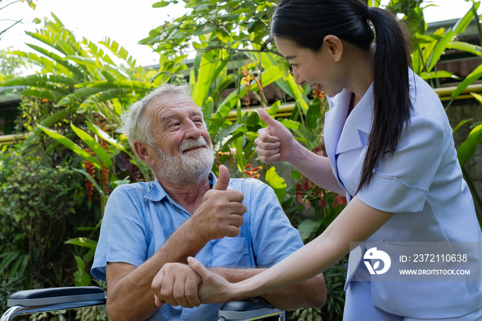 senior man happiness sitting on wheelchair with smiling nurse, takes care and discussion and cheer i