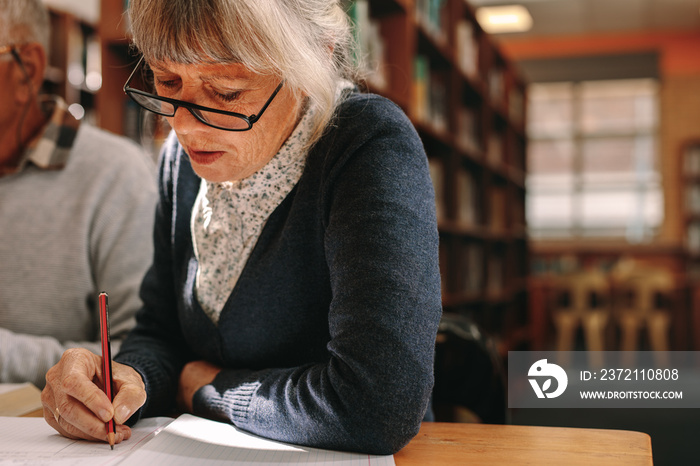 Close up of a senior woman writing in her book