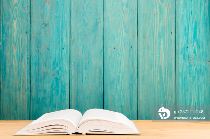 Open book on the desk over wooden background