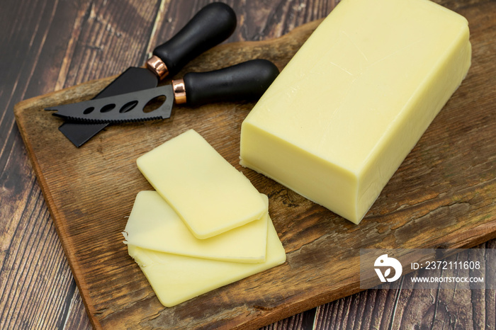 Kashar cheese or kashkaval cheese on wooden background. Sliced Cheddar Cheese