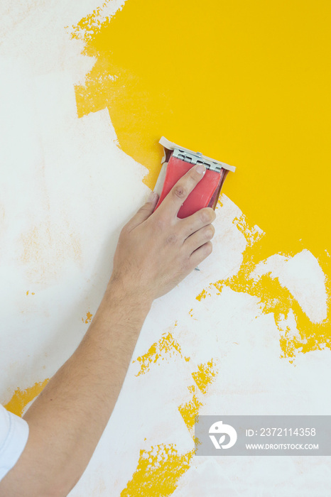 Sanding wall with a sanding block after skim coating. Preparation before painting. Renovation house 