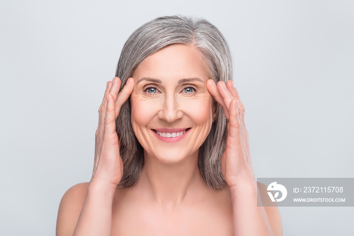 Photo of happy positive cheerful old woman hold hands temples wrinkles isolated on grey color backgr