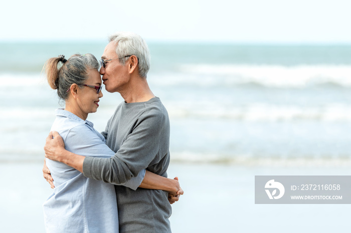 Asian Lifestyle senior couple hug and kiss on the beach happy in love romantic and relax time.  Peop