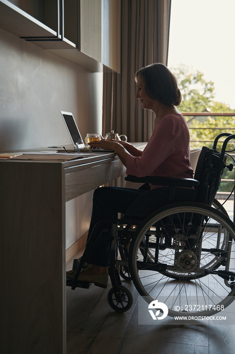 残疾女性在办公桌上用笔记本电脑工作