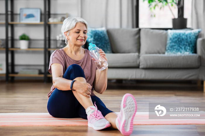 运动、健身和健康的生活方式理念——微笑的老年女性在家里的垫子上锻炼
