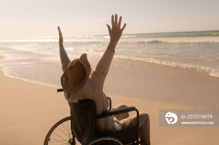 Disabled senior woman with arms up on the beach