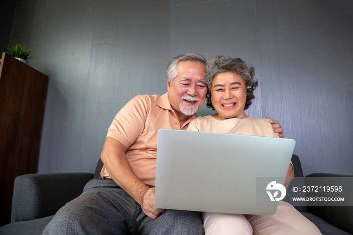 亚洲老年夫妇在笔记本电脑上进行视频通话聊天，老年智能技术和