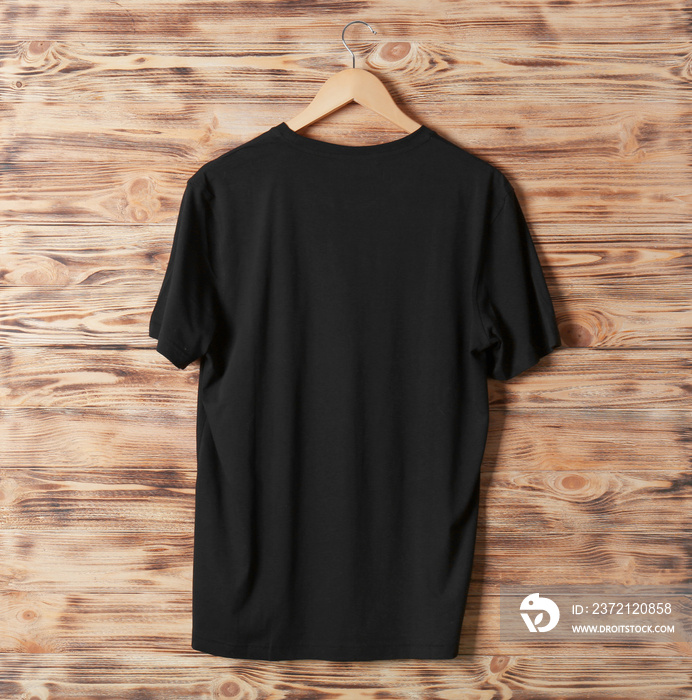 Blank black t-shirt against wooden background