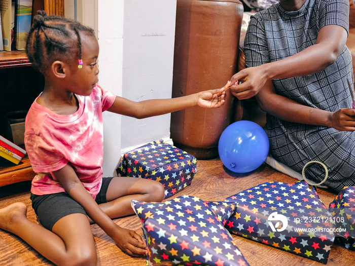 Mother with daughter wrapping birthday presents