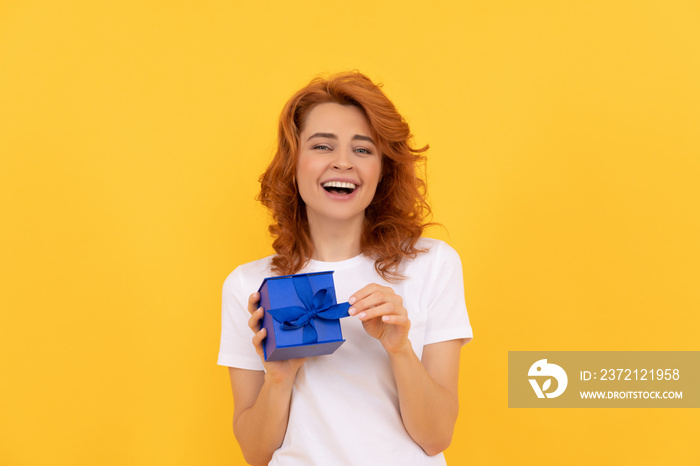 seasonal sales. laughing girl with box on yellow background. boxing day.