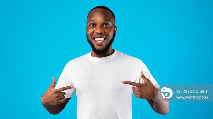 African Guy Pointing Fingers At Himself Posing Over Blue Background