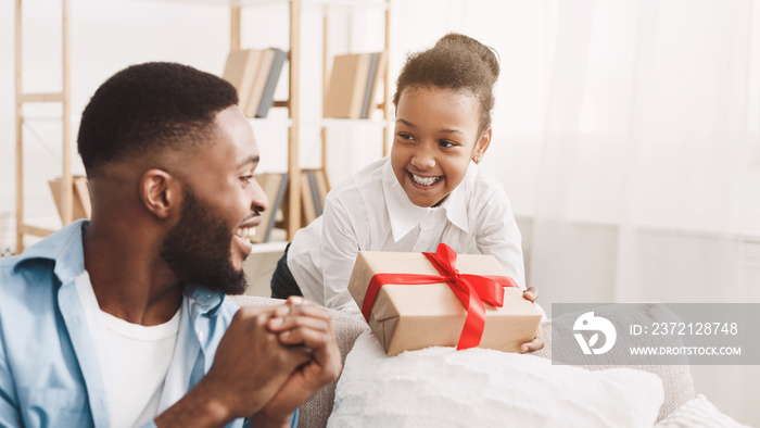 Adorable black girl giving handmage girl to father